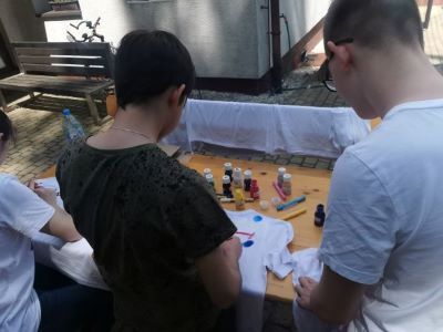 Dwaj wolonatriusze malujący koszulki.