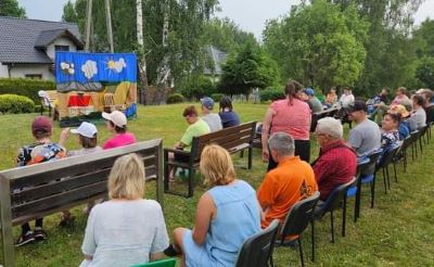Na zdjęciu widać ludzi oglądających występ teatru plenerowego.